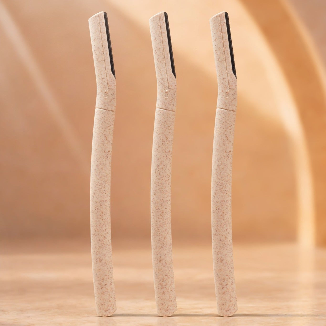 Three beige makeup shape with black bristle tips on a beige background
