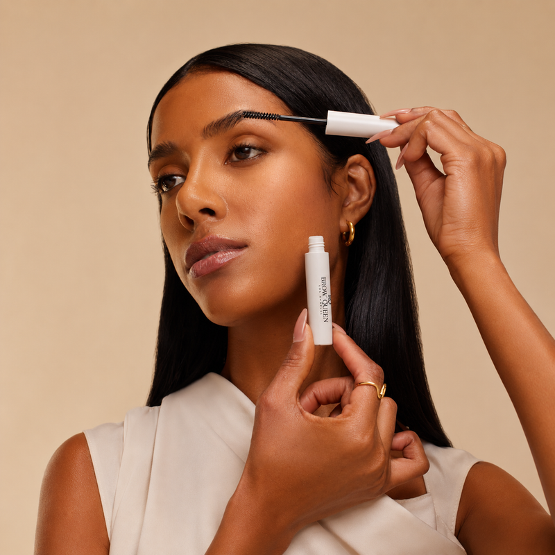 Woman applying gel set with a white cylindrical product against a beige background