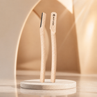 Two wooden brushes on a white stand against a beige background