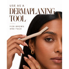 Woman using the dermaplaning tool on her brow to shape hairs and remove peach fuzz from the face.