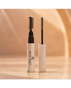 Brow Gel dual-ended applicators with comb and spoolie tips, shown upright on a warm beige background.