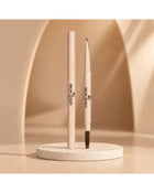 Dual-ended Eyebrow Pencil on a textured pedestal, showing the precision tip and spoolie brush for shaping and filling brows.