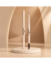 Dual-ended Eyebrow Pencil on a textured pedestal, showing the precision tip and spoolie brush for shaping and filling brows.